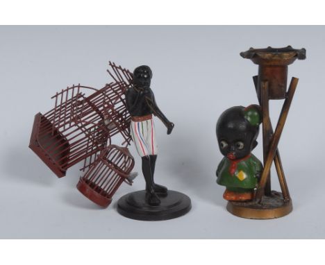 An early 20th century painted spelter novelty figural candlestick, cast as a young black schoolboy, circular base, 12.5cm hig
