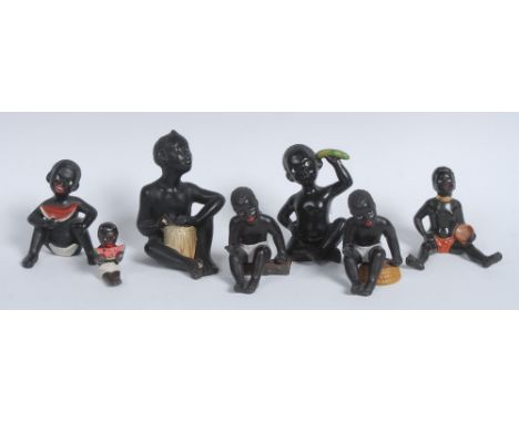 An early 20th century slip-cast novelty comical model, modelled as a young black boy holding a banana to his ear as a telepho