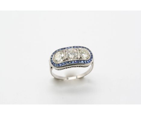 A SAPPHIRE AND DIAMOND RING centred with three brilliant-cut diamonds weighing 2.10 carats in total within a surround of cali
