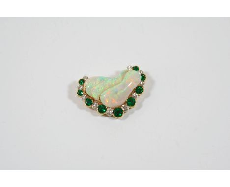 AN OPAL, EMERALD AND DIAMOND BROOCH formed with three overlapping sections of opal within a surround of alternate circular-cu