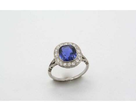 A SAPPHIRE AND DIAMOND CLUSTER RING the oval-shaped sapphire is set within a surround of circular-cut diamonds. Size L.