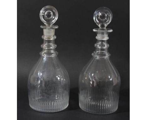 A MATCHED PAIR OF GEORGIAN GLASS DECANTERS AND STOPPERS, of mallet form with three ring necks, bulls eye stoppers and faceted