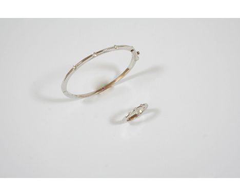 AN 18CT. WHITE GOLD AND DIAMOND BANGLE the half hinged bangle is mounted to one side with three circular-cut diamonds, intern