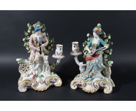 PAIR OF DERBY STYLE MUSICIAN CANDLESTICKS, late 19th century, possibly Samson, he with bagpipes and a hound, she with a lute 