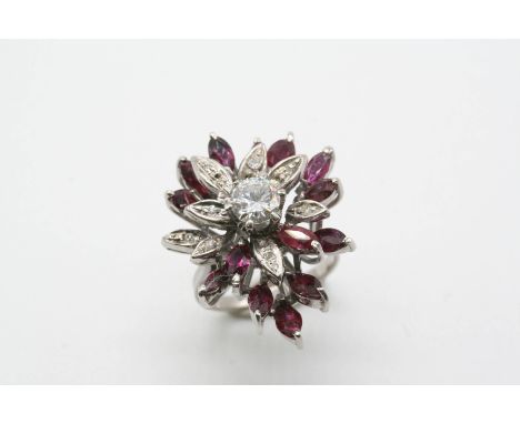 A RUBY AND DIAMOND CLUSTER RING the flowerhead design is centred with a circular-cut diamond, with marquise-cut rubies and ci