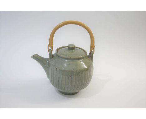 DAVID LEACH - STUDIO POTTERY TEAPOT a large cut sided stoneware teapot with a celadon glaze and bamboo handle. Seal mark to b