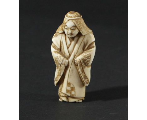 JAPANESE IVORY NETSUKE, Meiji, carved as a figure standing in a full length robe, signed, height 4cm