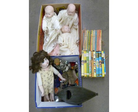 An Action Man figure, clothing and a Cherilea canoe, three porcelain head dolls, a crib and a collection of children's books,