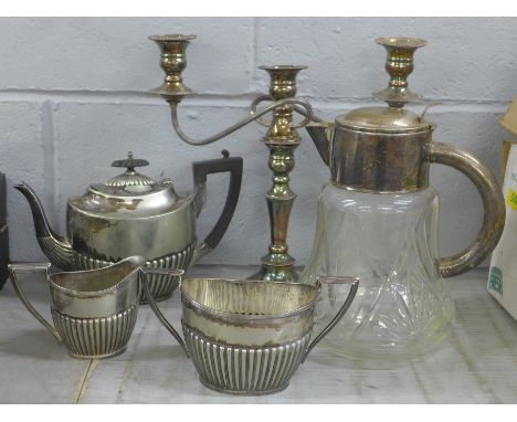 A collection of plated ware including a Walker &amp; Hall teapot, sugar bowl and milk jug, and a candelabra **PLEASE NOTE THI