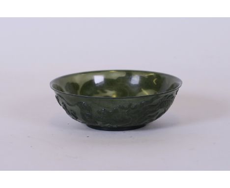 A Chinese spinach jade trinket dish with carved decoration of a dragon chasing the flaming pearl, carved seal mark to base, 3