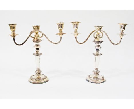 A pair of 20th Century silver plated three light candelabra, each with shaped square detachable nozzles to urn-shaped sconces