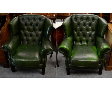 A pair of green leather button back wing chairs 