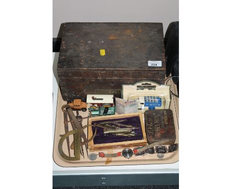 An antique pine box containing a small quantity of hand tools, precision drawing instruments, folding wooden rule, bank notes