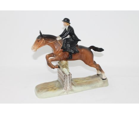 A Beswick figure of a huntswoman riding side saddle on a leaping horse, No. 982