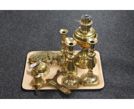 A tray of brass ware including candlesticks, desk bell, trivets, oil lamp etc 