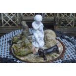 A dog shaped cast iron boot scraper and various garden ornaments.