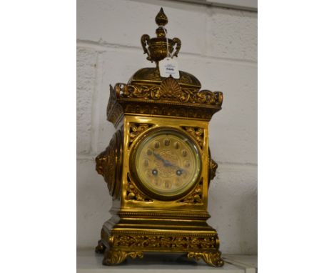An ornate brass mantle clock.