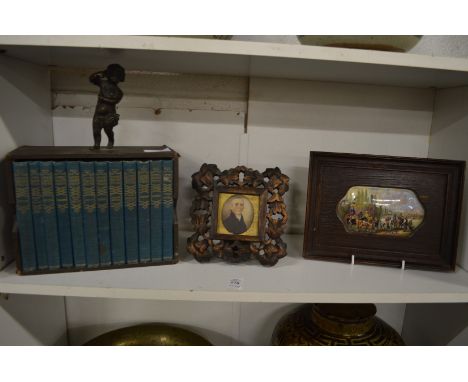 A miniature set of books, miniature portrait of a gentleman and a framed pot lid.