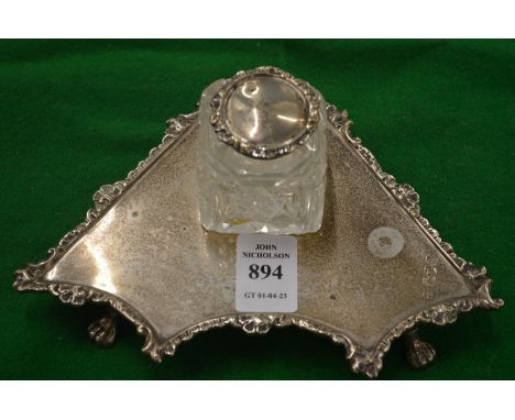 A silver inkstand with cut glass inkwell.