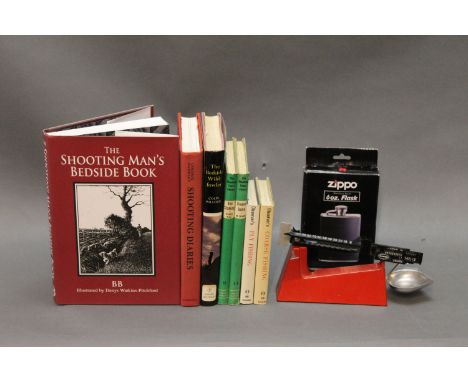 Seven books to include "The Shooting Mans Bedside Book together with some powder scales and a Zippo 6 oz hip flask.