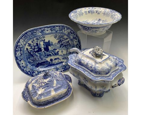 An 1820s, earthenware blue and white meat plate 43x32.5cm depicting waterside ruins and figures with a packhorse in a floral 