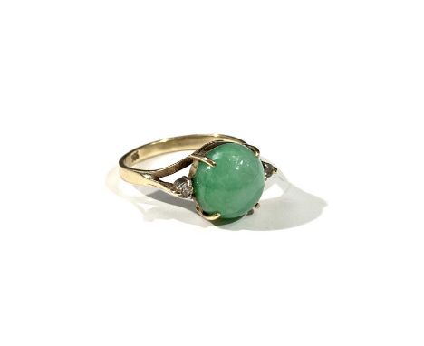 A 14ct gold ring set with jade flanked by small white stones