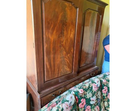 A fine 18th century mahogany linen press, with narrow carved frieze, with two well figured fielded panel doors enclosing a la