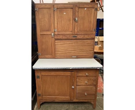 A mid century American kitchen dresser unit, the upper part with tambour shutter and cupboards, the lower part with enamel to