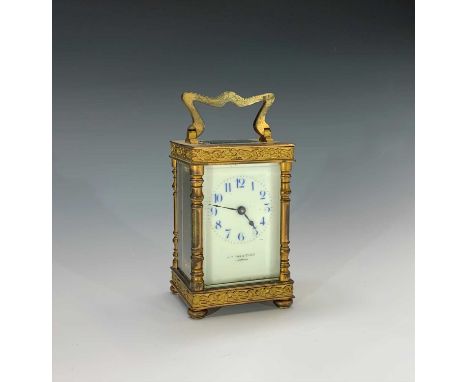 A late 19th century French gilt brass carriage clock, with applied floral banded decoration, the dial with blue enamelled Ara