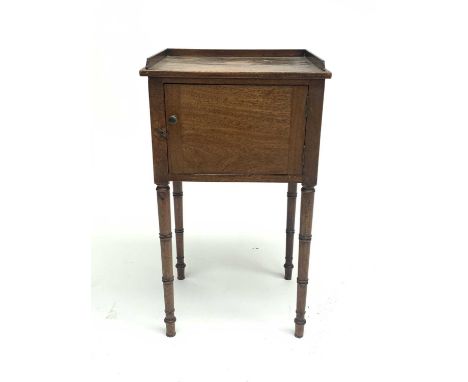 A late George III mahogany bedside cupboard, with three quarter gallery above a single door, on ring turned legs, height 81cm