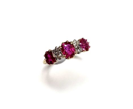 An 18ct gold ruby and diamond ring the three graduated rubies divided by pairs of diamonds