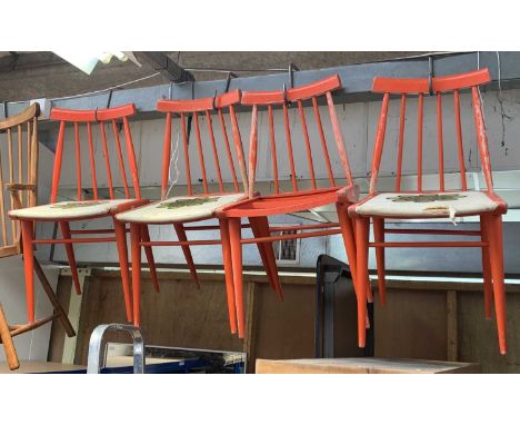 A set of four mid century Scandinavian dining chairs, red painted, with stick backs, the linen seats painted with stylised fl