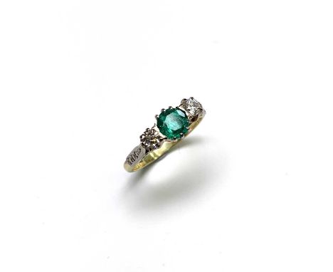 An 18ct yellow gold ring set an emerald of almost 1ct and two diamonds