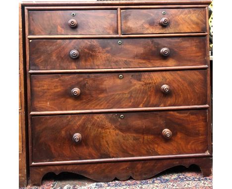 A Victorian mahogany veneered chest of two short and three long drawers with wooden knobs on bracket feet with shaped apron w