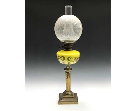 A late 19th/early 20th century oil lamp, with brass fluted shaft and stepped square base, the yellow reservoir with hand pain