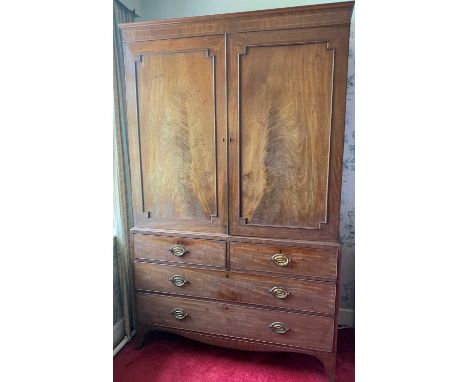 A Regency mahogany linen press, the upper part with two panel doors enclosing four sliding shelves, the lower part with two s