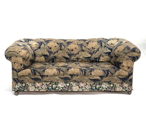 An upholstered Chesterfield type sofa, with floral loose cover, on castors, overall width 192cm. Provenance: From Penrose Hou