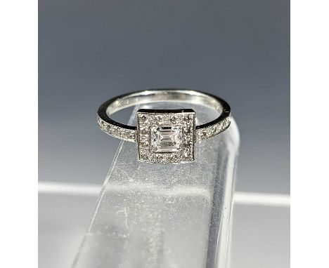 A Tiffany diamond ring in 950 platinum, the principle stone, an emerald-cut diamond of 0.33 cts this within a band of diamond