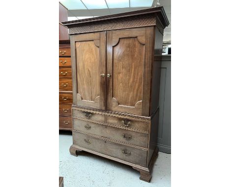 A fine Chippendale period linen press with dentilled cornice over a blind fret frieze of trellis-work and carved scrolling. T