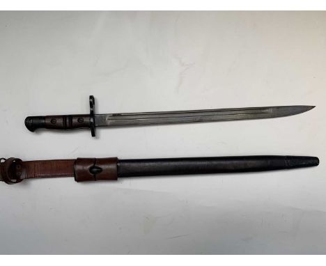 A US Remington 1913 pattern bayonet, with two piece wooden grip, leather scabbard and 1940 leather frog, overall length 59cm.