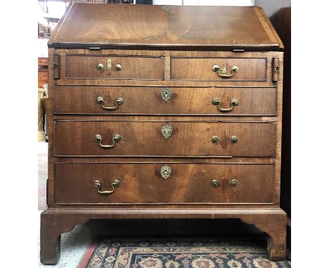 A George III mahogany bureau, the fall front enclosing a fitted interior, above two short and three long drawers on bracket f