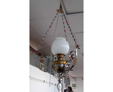 A hanging oil lamp, the wrought metal frame with copper flower head decoration .Overall height 100cm.
