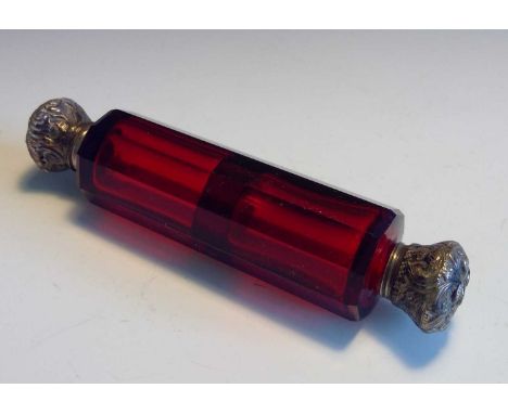 A late 19th/early 20th century double ended faceted ruby glass perfume bottle with hinged white metal caps. Length 12.5cm.