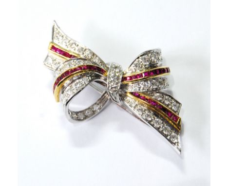 Diamond and calibré ruby bow brooch in white gold, '18ct'. Condition Report 13g gross.  47mm x 30mm approximately.  The whole