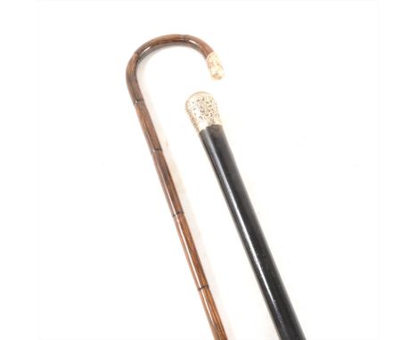 An Edwardian ebonised walking cane with a silver pommel, London 1909, 84cm; and a bamboo walking stick with silver terminal. 