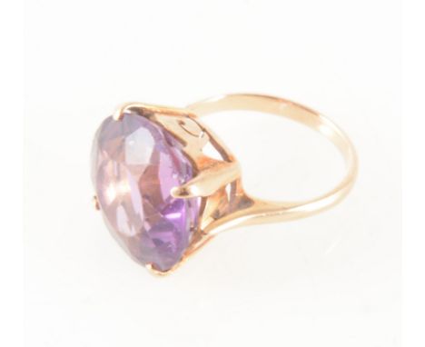 An amethyst dress ring, the 16mm diameter brilliant cut stone four claw set in a rose metal mount ring size K/L.