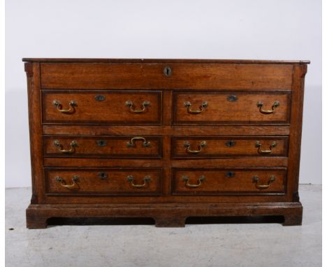 A Georgian oak Lancashire type mule chest, with a hinged lid, front fascia, fitted with two dummy drawers over four drawers, 