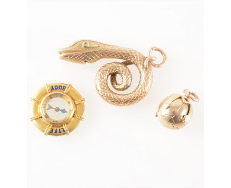 Three vintage charms, a yellow metal 40mm coiled snake whistle, a 20mm Life Buoy and a 4.7mm yellow and white metal folding M