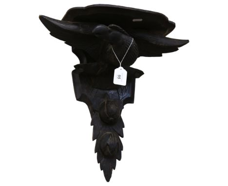 An ebonised carved wood clock bracket, mythical bird support, W45cm, H40cm 