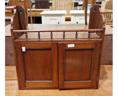 Edwardian mahogany hanging wall cupboard with spindle top rail and two panel doors opening to a shelf, 50cm high x 50cm wide